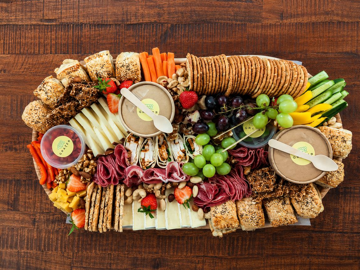 Large graze platter with cheeses, cured meats, fruit and crackers