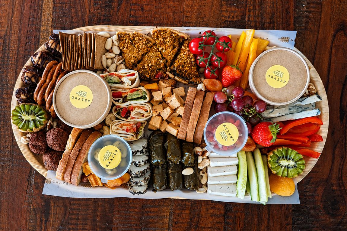 Vegetarian graze platter with cheeses, olives, hummus and rustic bread
